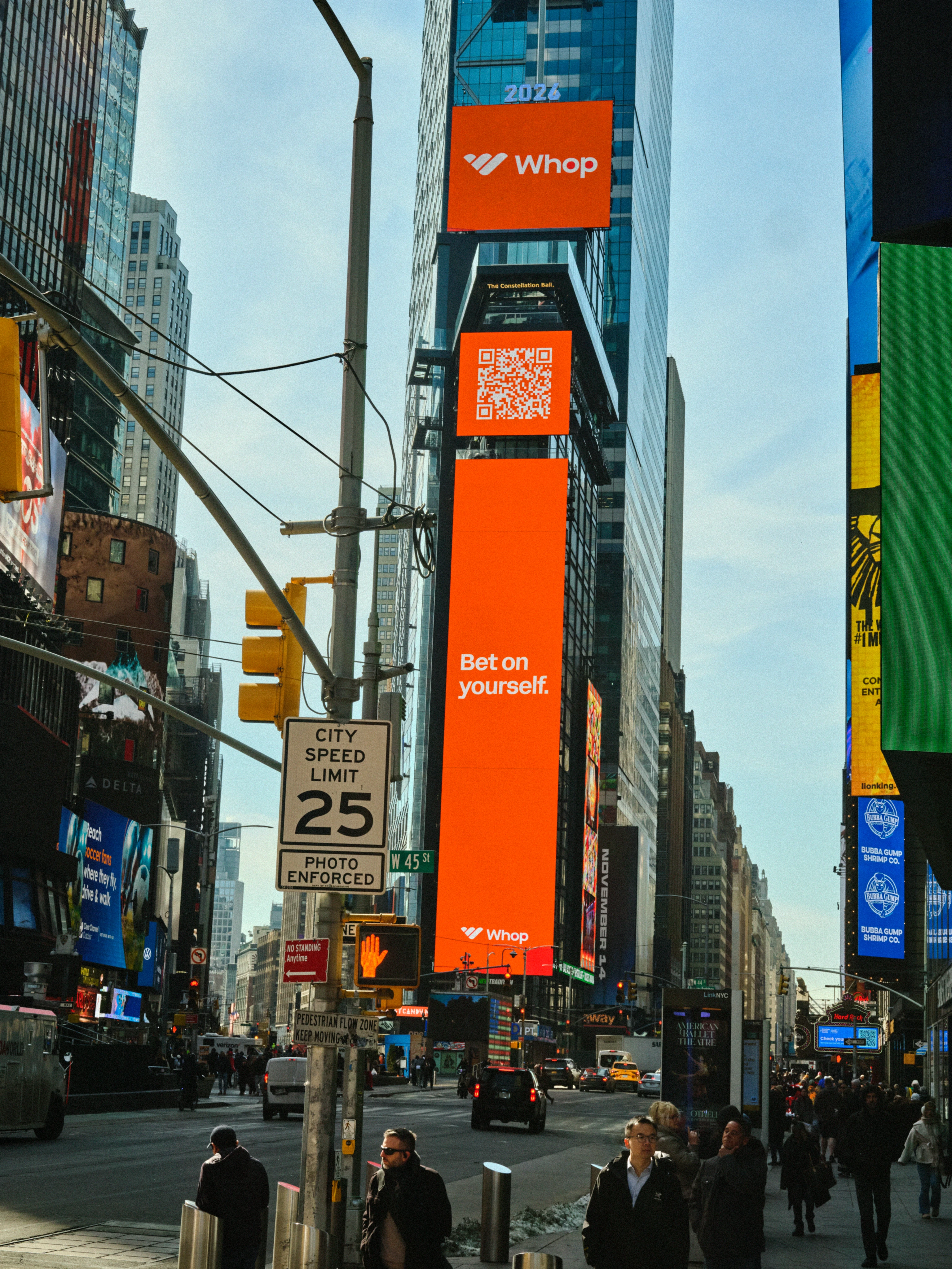 A Whop billboard reading Bet on yourself above a street in Times Square