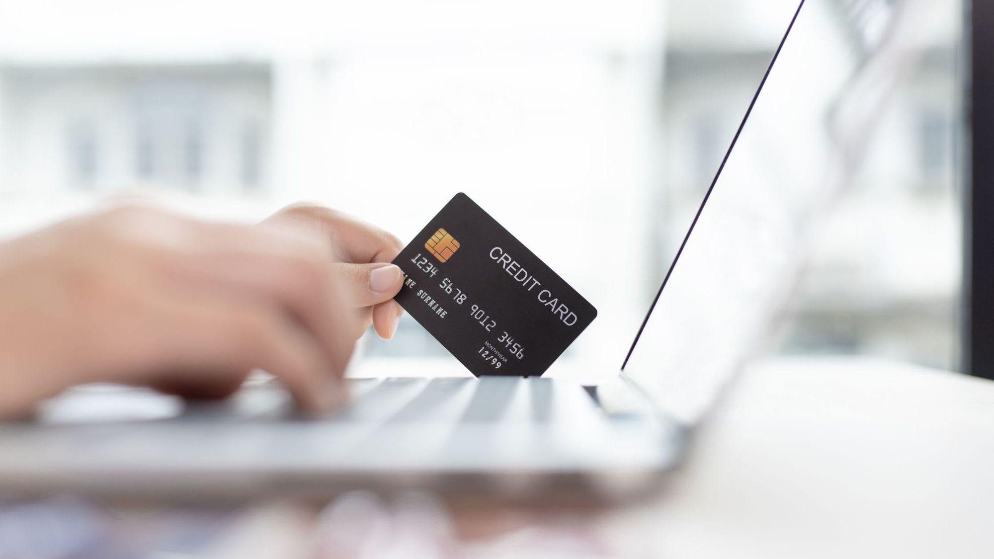 Woman online shopping with a credit card and payment processor