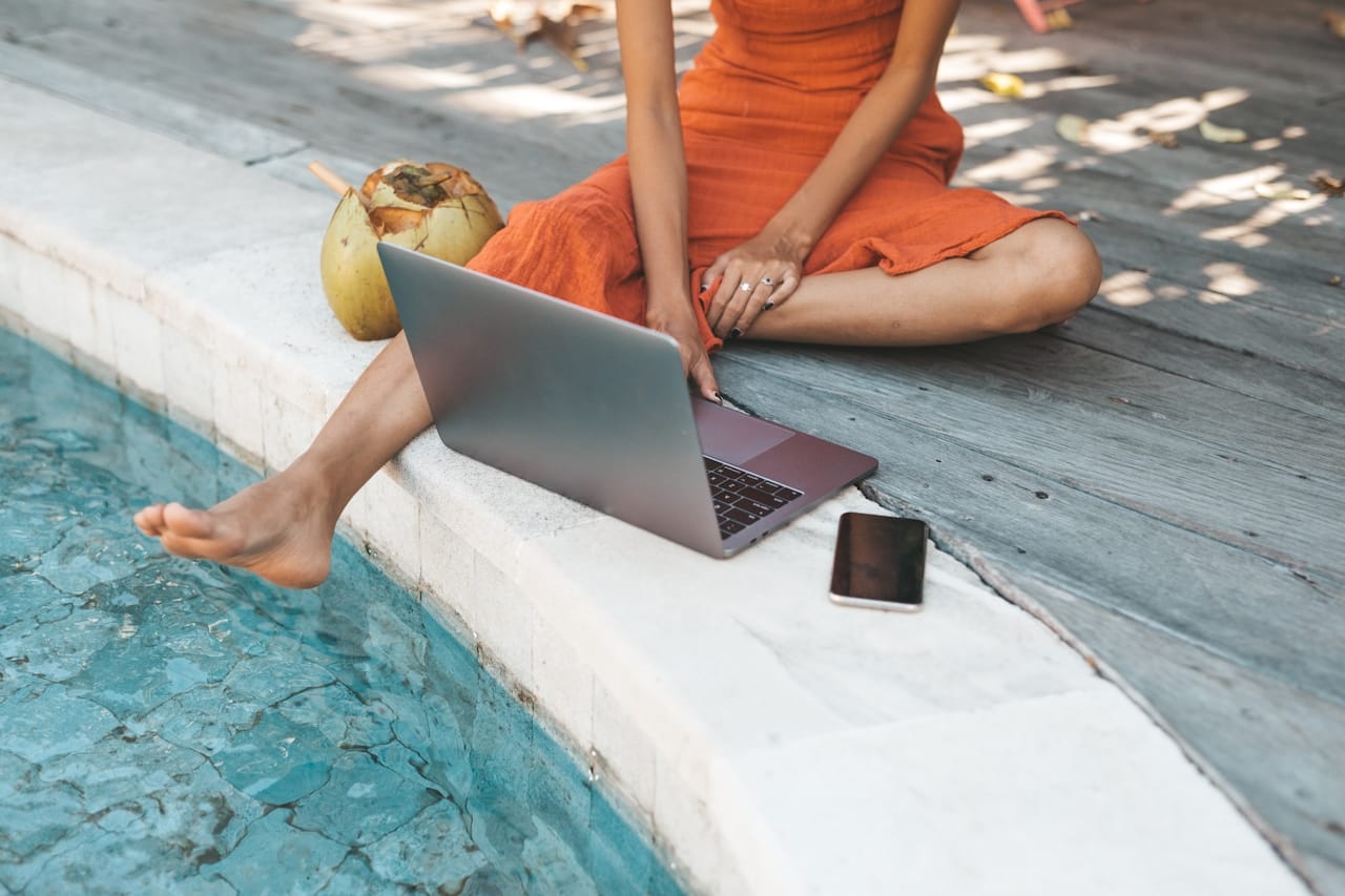 woman working on laptop from pool